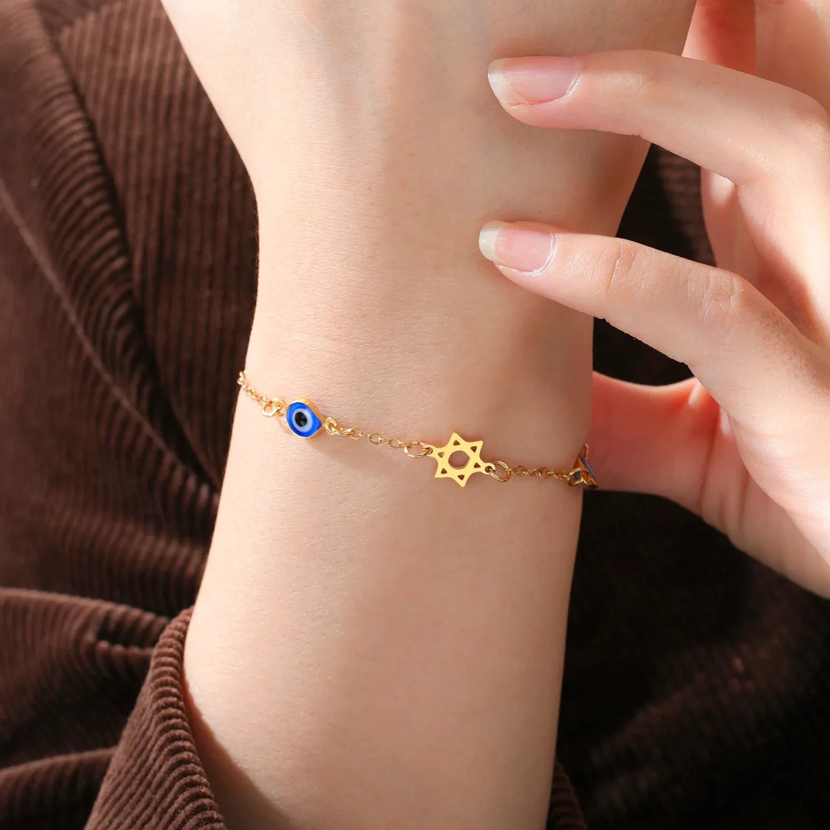 Bracelet with protective symbols: blue eye, Chai, and the Star of David in gold