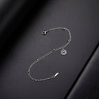 Gold-tone bracelet with small silver spiral charm