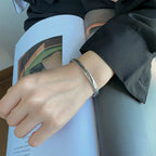 Open bangle bracelet with silver-tone feather