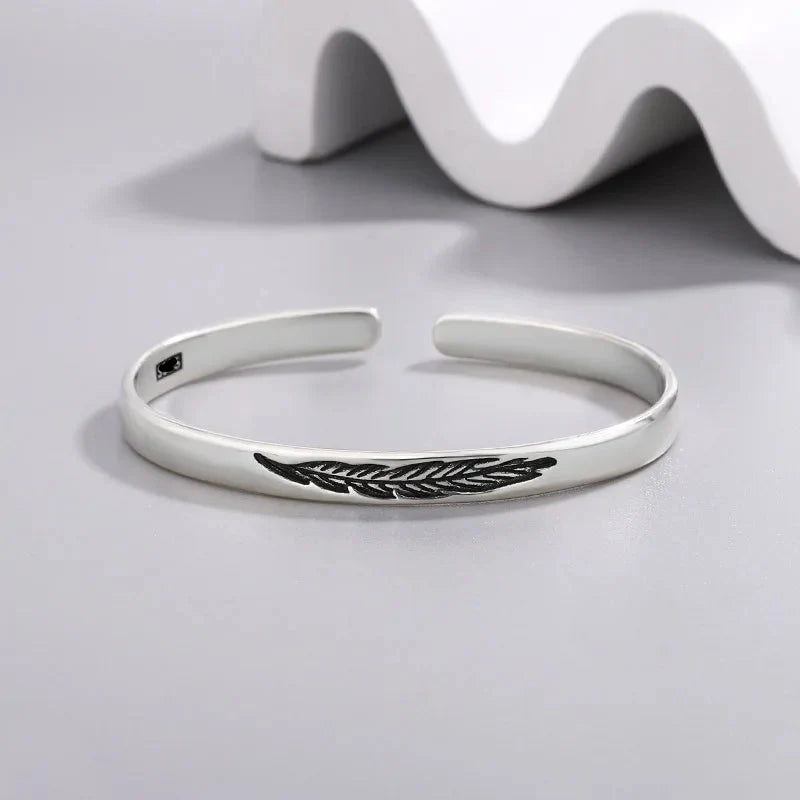 Open bangle bracelet with silver-tone feather