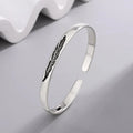 Open bangle bracelet with silver-tone feather