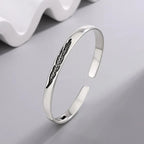 Open bangle bracelet with silver-tone feather