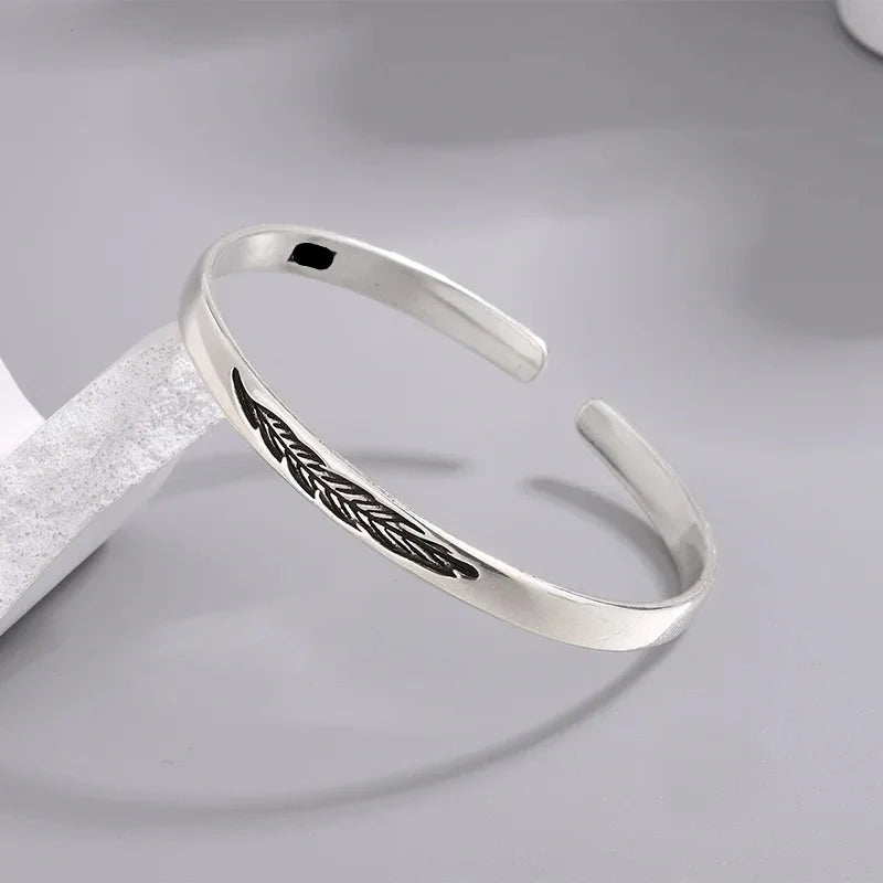 Open bangle bracelet with silver-tone feather