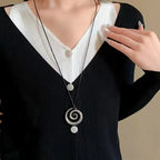 Long necklace with silver-toned spiral pendant
