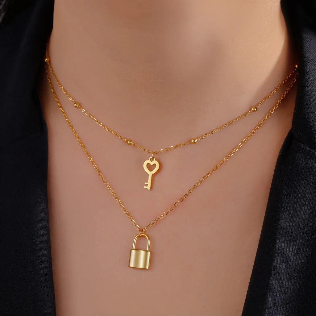Double necklace with key and lock pendant in gold