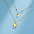 Double necklace with key and lock pendant in gold