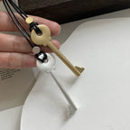 Long cord necklace with matte silver key pendant