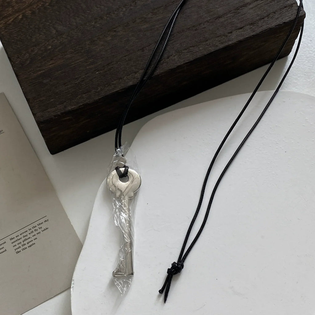 Long cord necklace with shiny silver key pendant