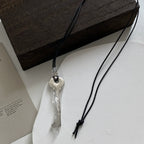 Long cord necklace with shiny silver key pendant