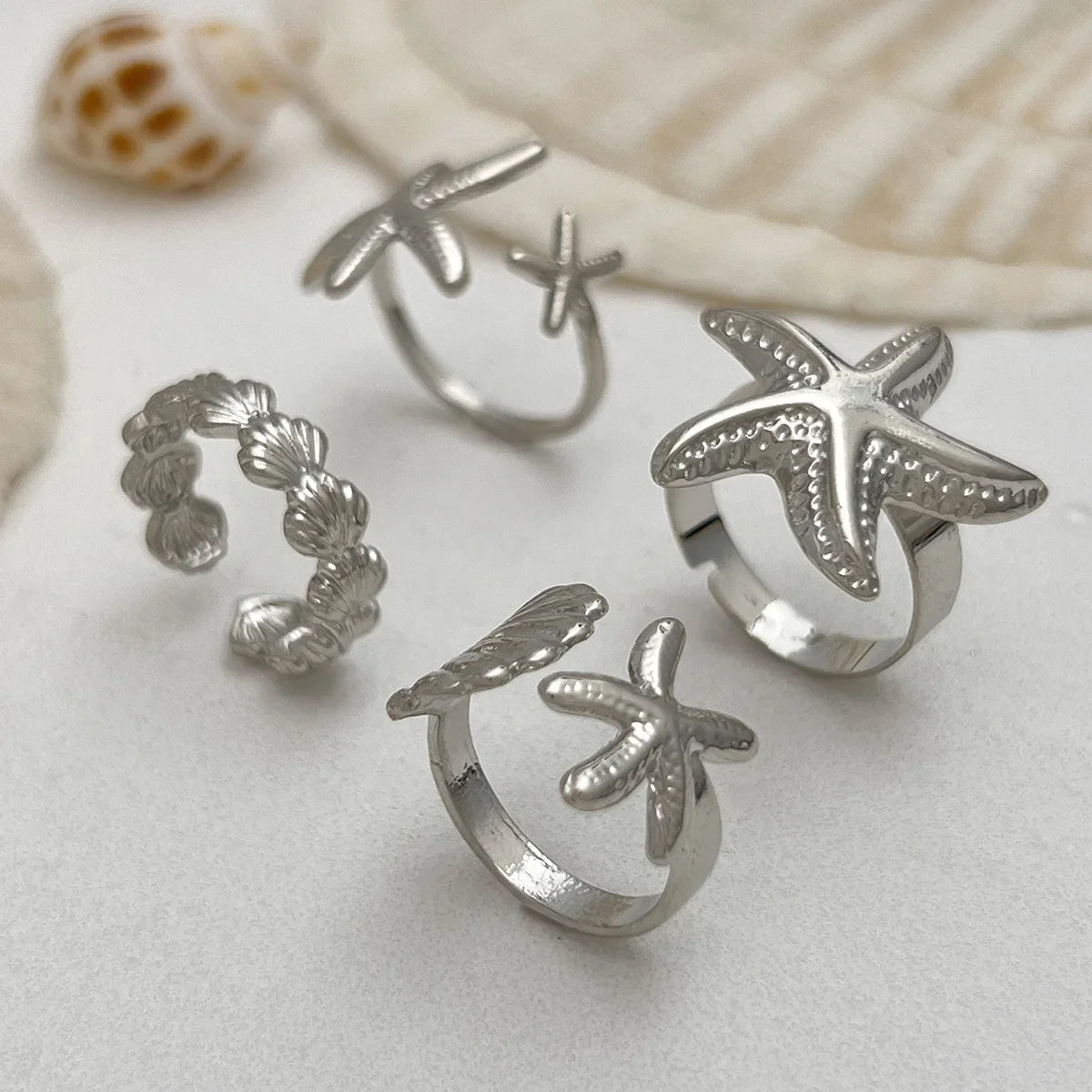 Set of 4 shell and starfish rings silver