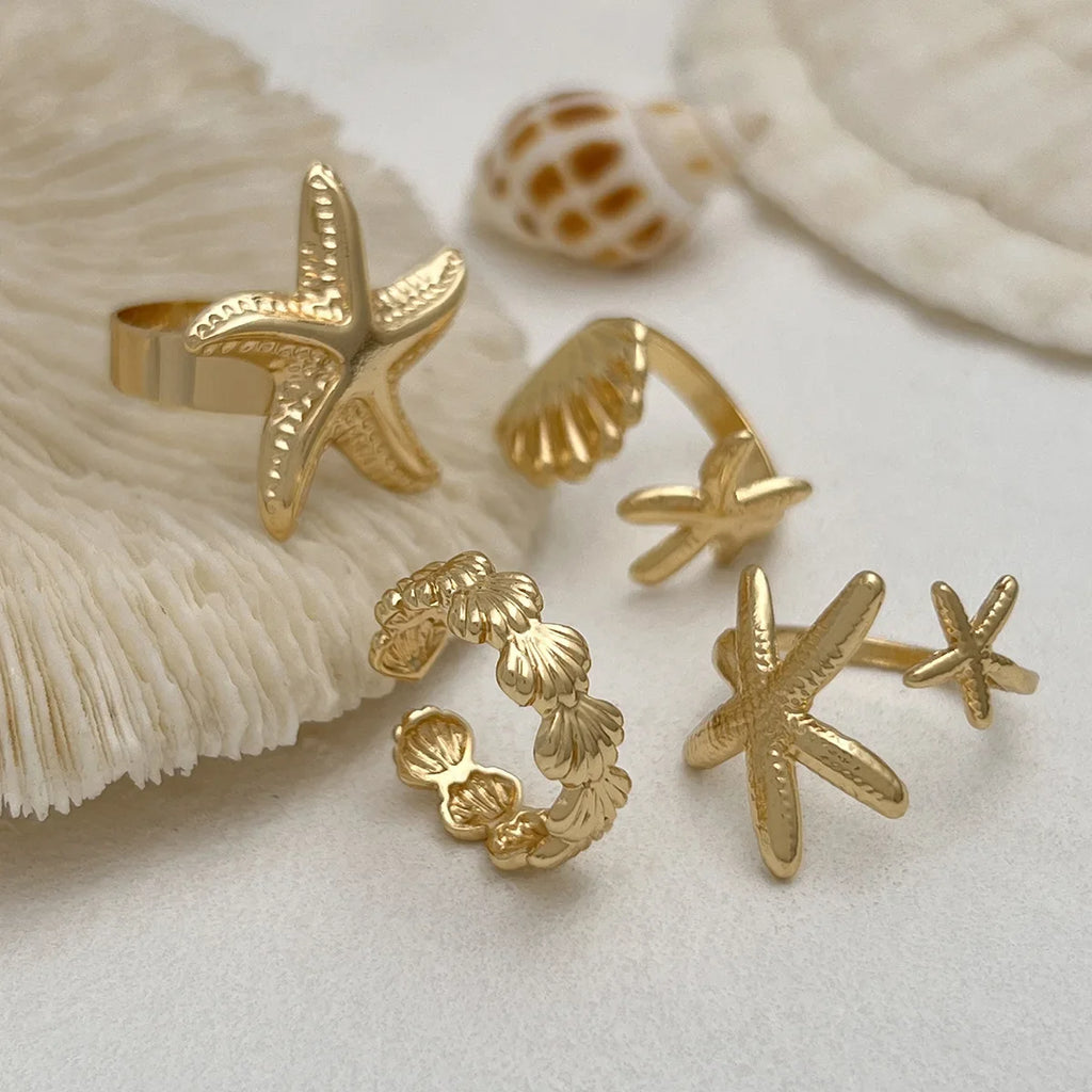 Set of 4 shell and starfish rings gold