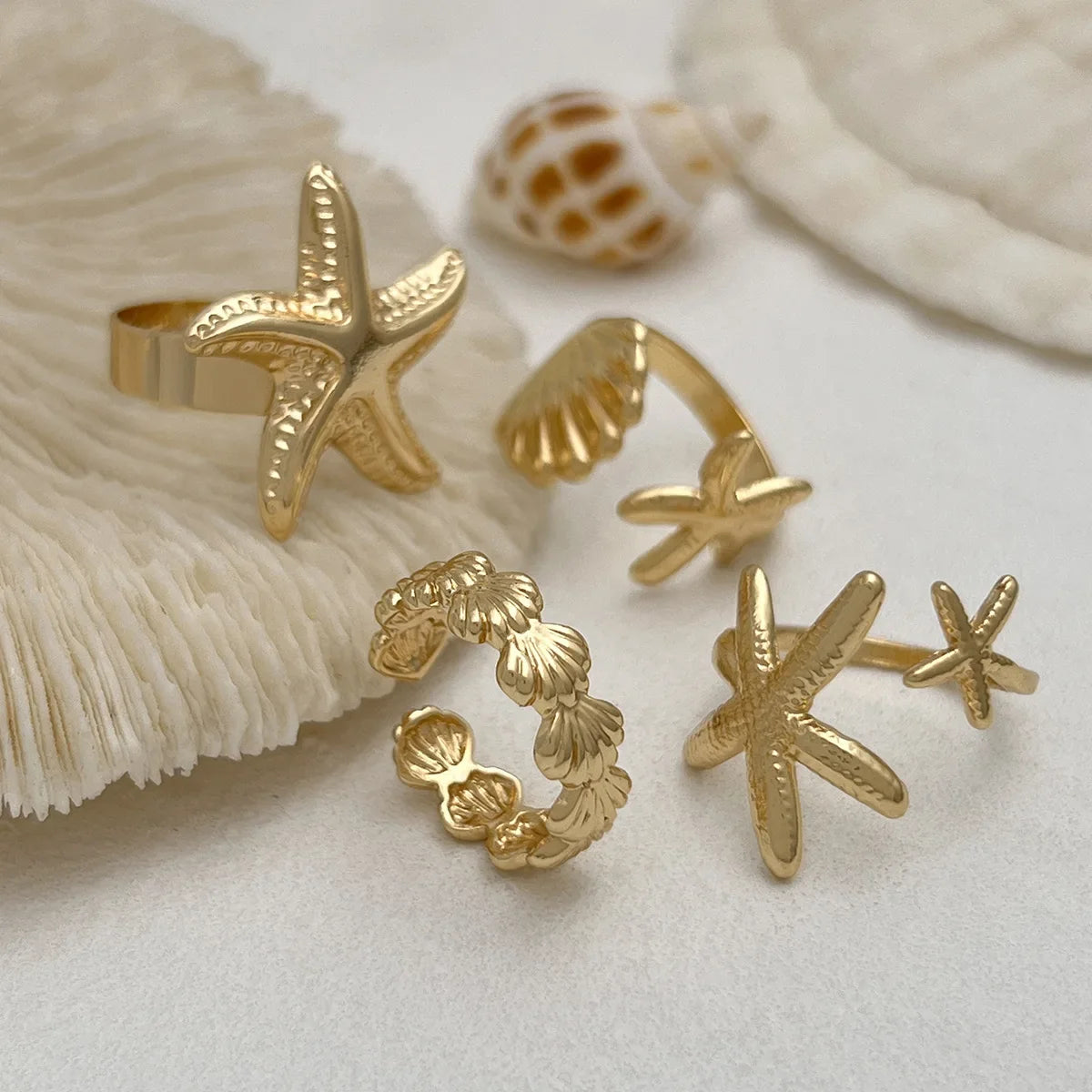 Set of 4 shell and starfish rings gold