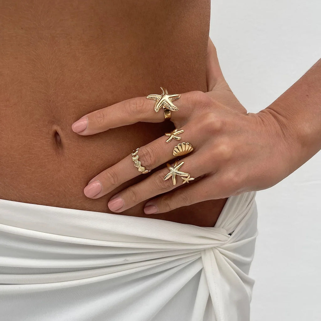 Set of 4 shell and starfish rings gold