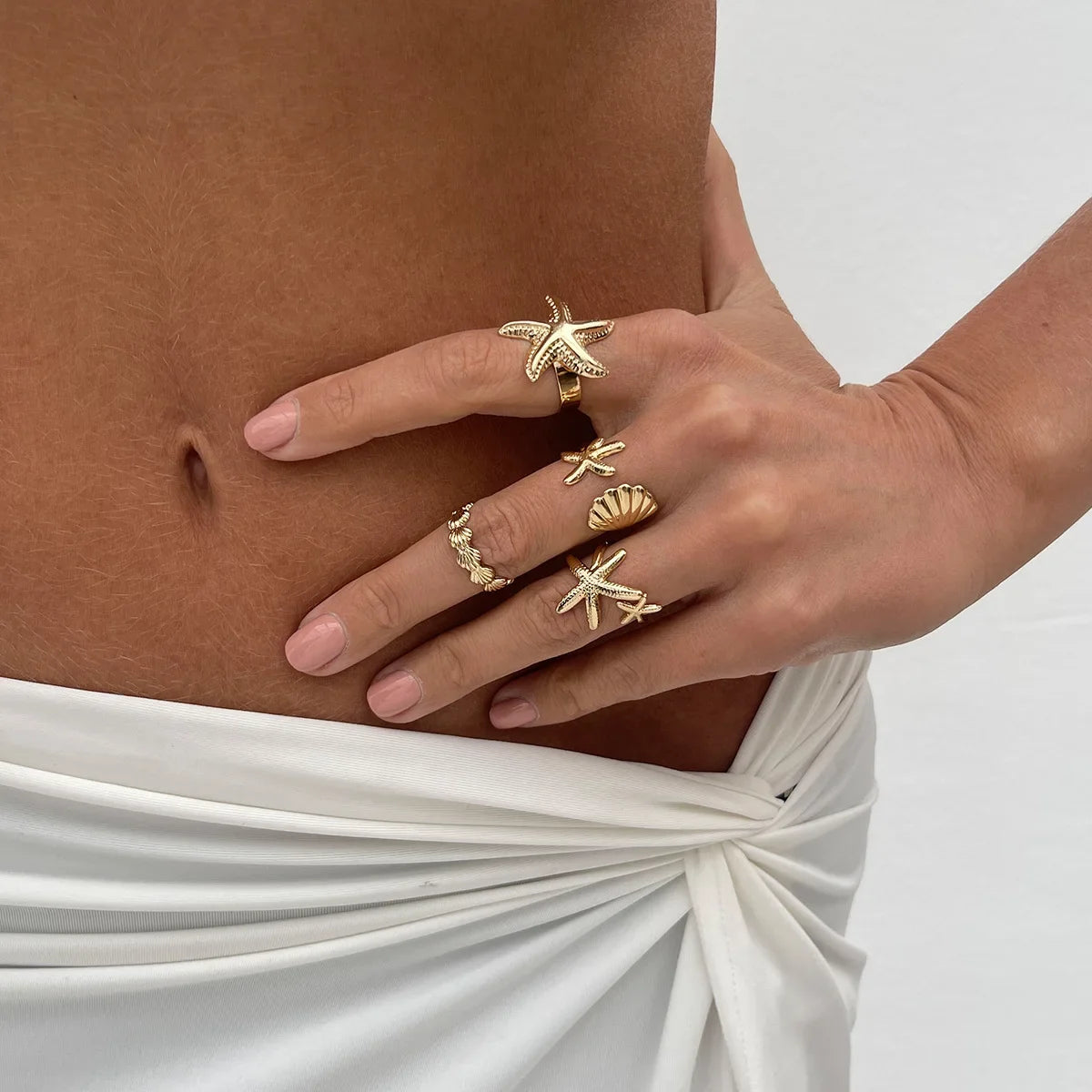 Set of 4 shell and starfish rings gold