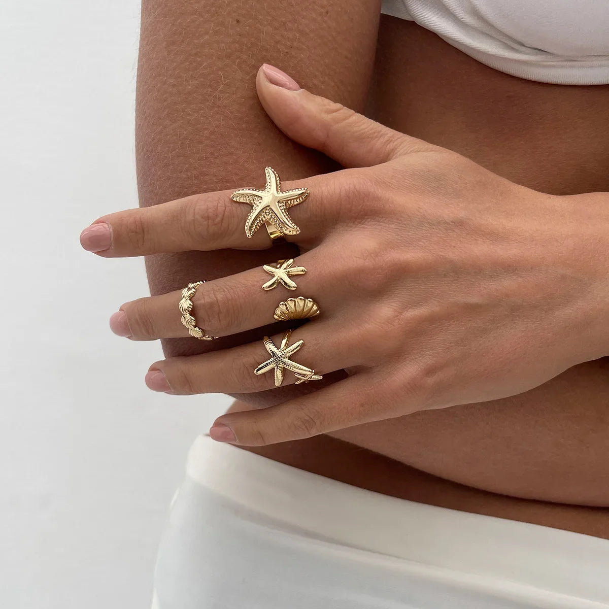 Set of 4 shell and starfish rings gold